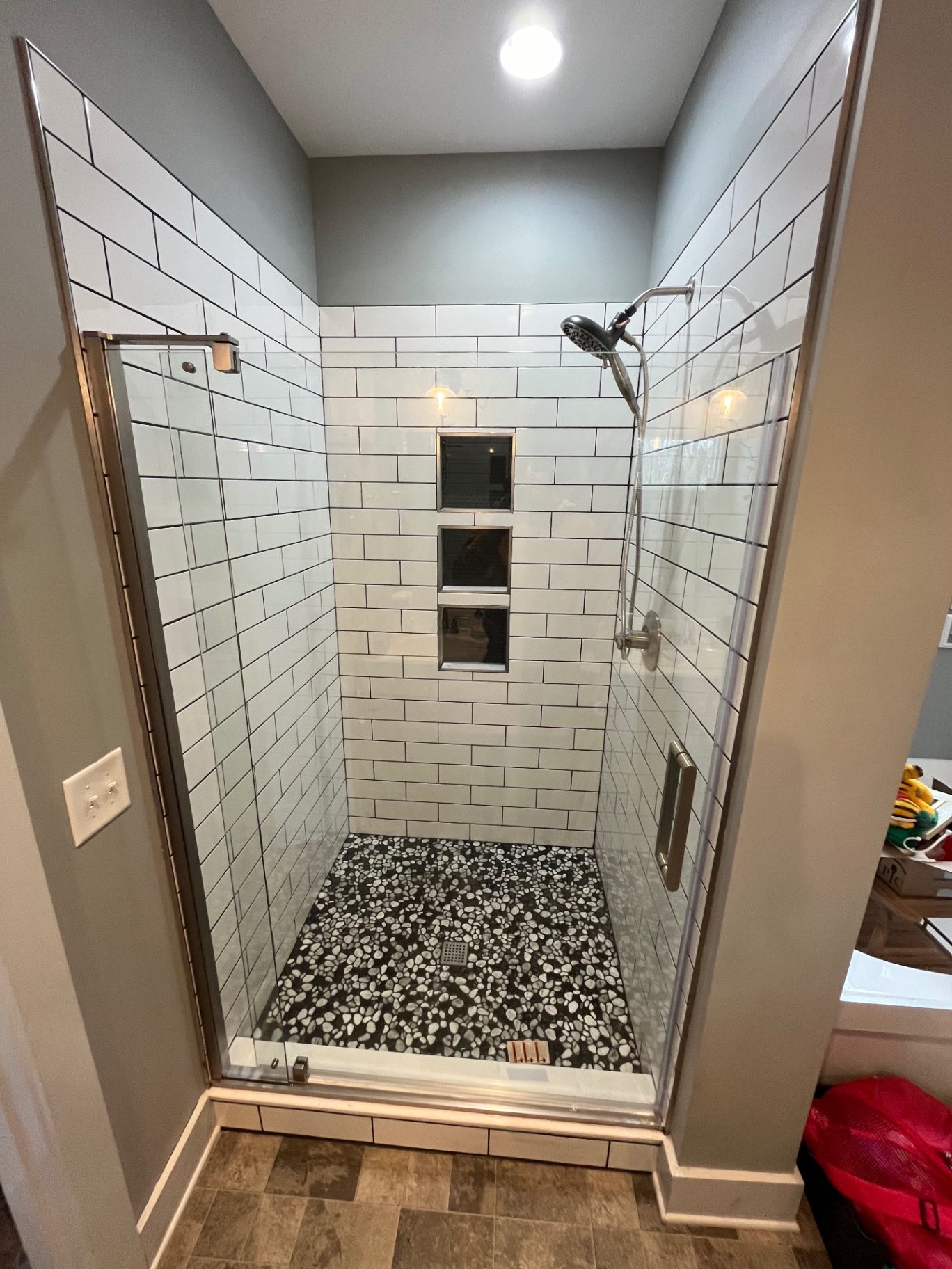 Subway tile shower with pebble floor