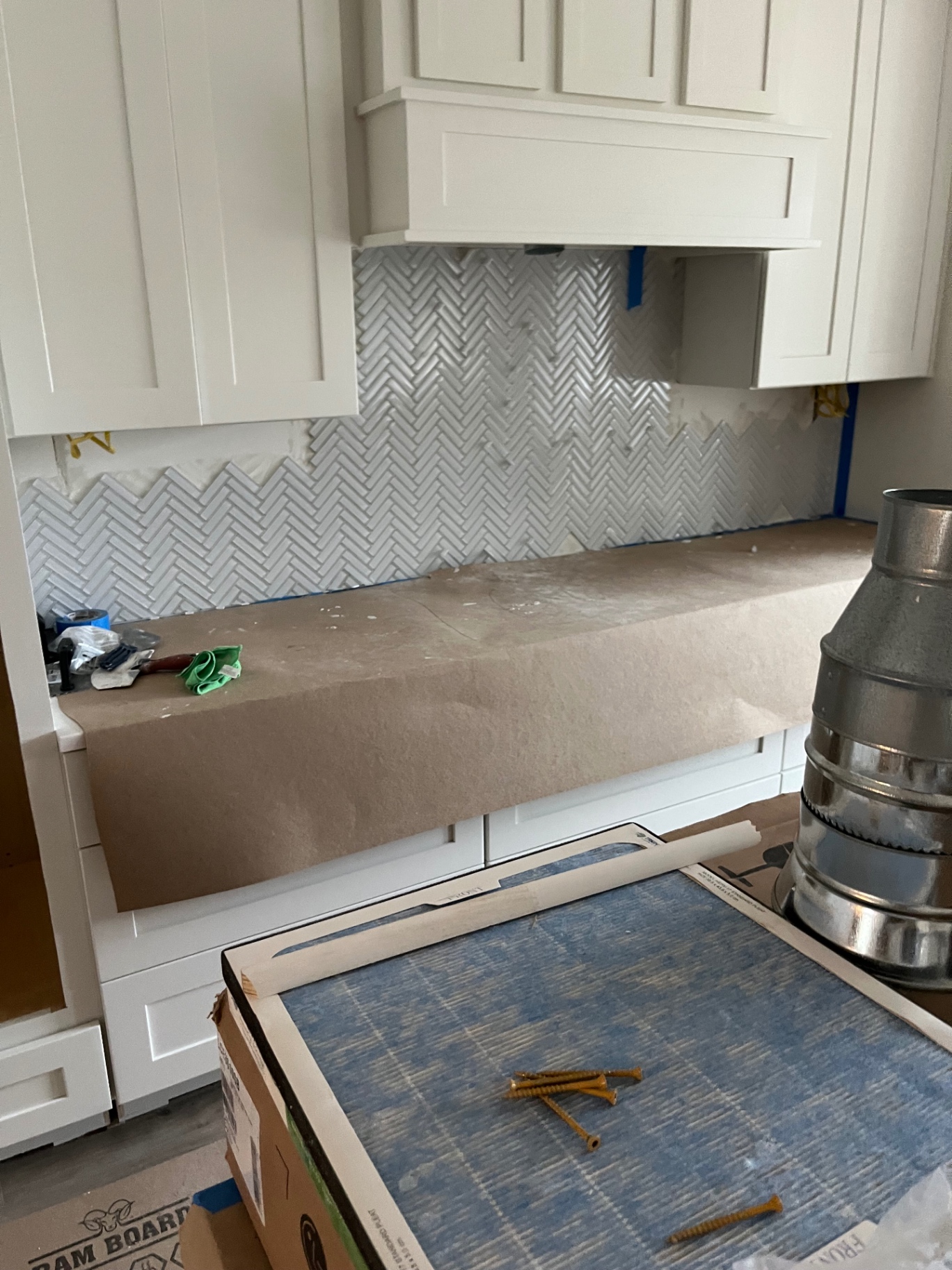 Marble herringbone backsplash under hood